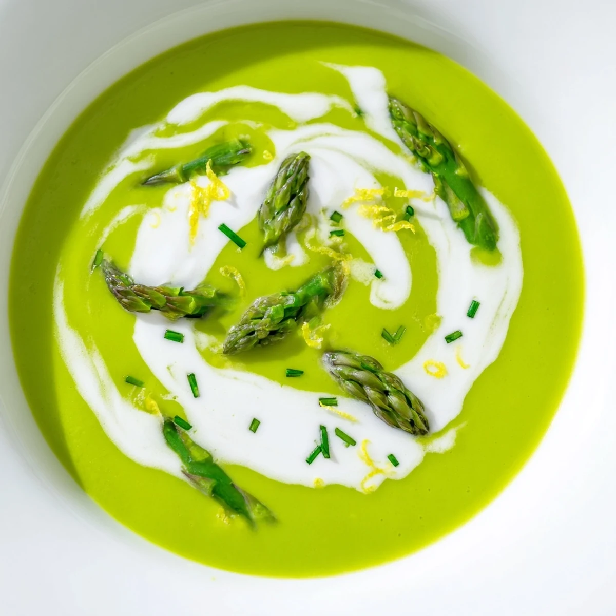 A bowl of Creamy Asparagus Soup with Lemon and Crème Fraîche, served with crusty bread for dipping.