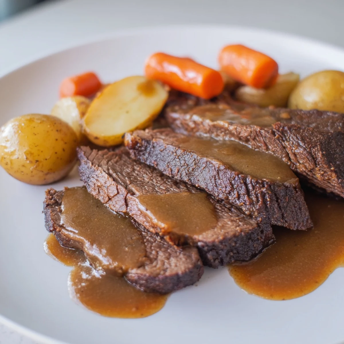 Tender Slow Cooker Pot Roast with Carrots served on a platter with savory pan juices.