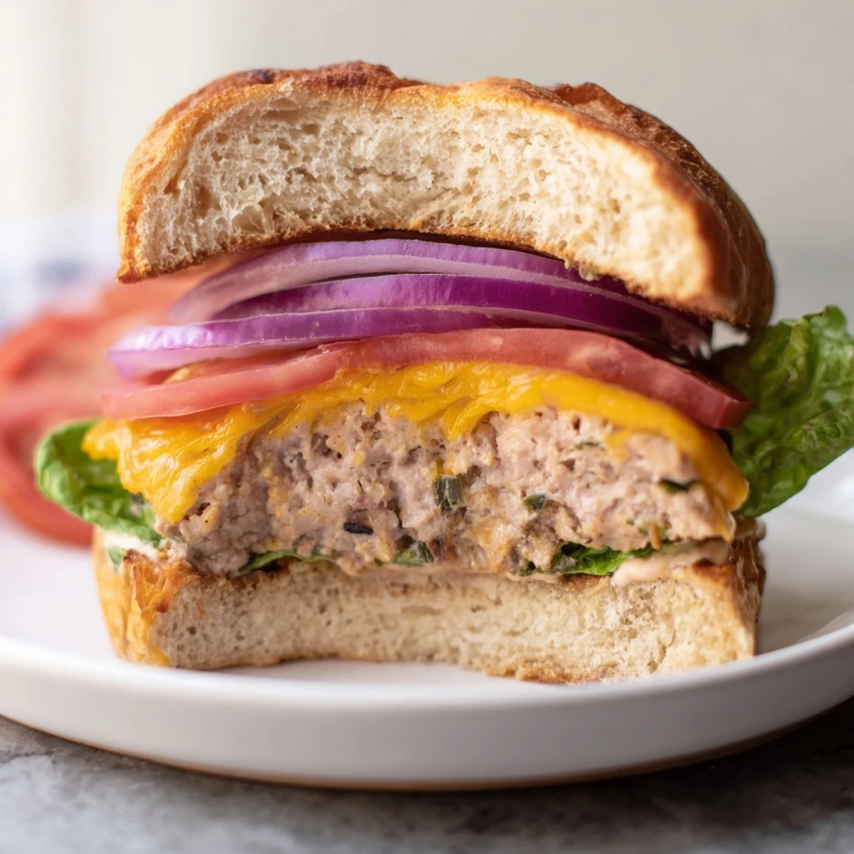 Freshly grilled turkey burger on a soft bun with melted cheese, crisp lettuce, and ripe tomato slices.