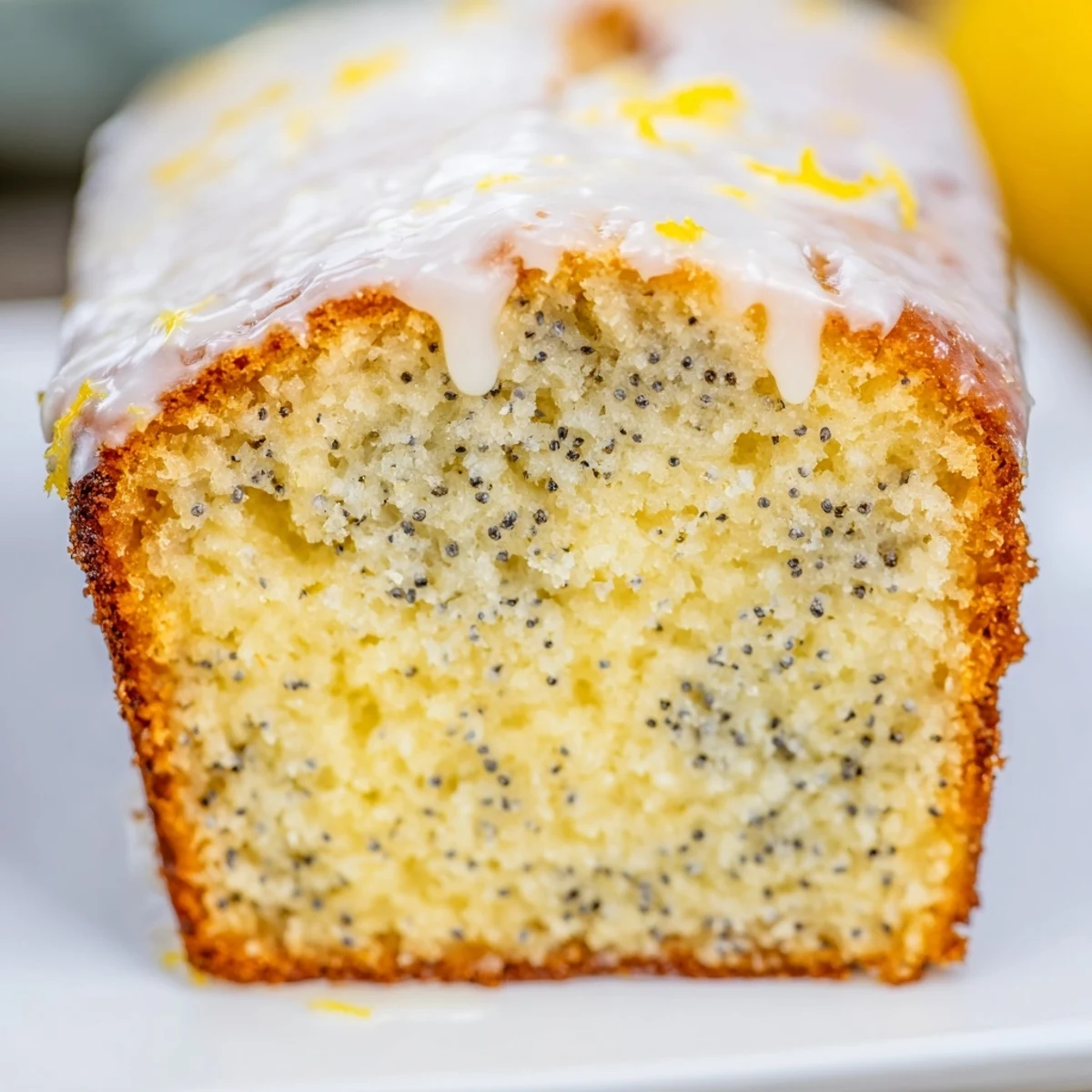 Golden slices of moist Lemon Poppy Seed Loaf with Lemon Glaze, showcasing tender crumb and bright citrus zest.