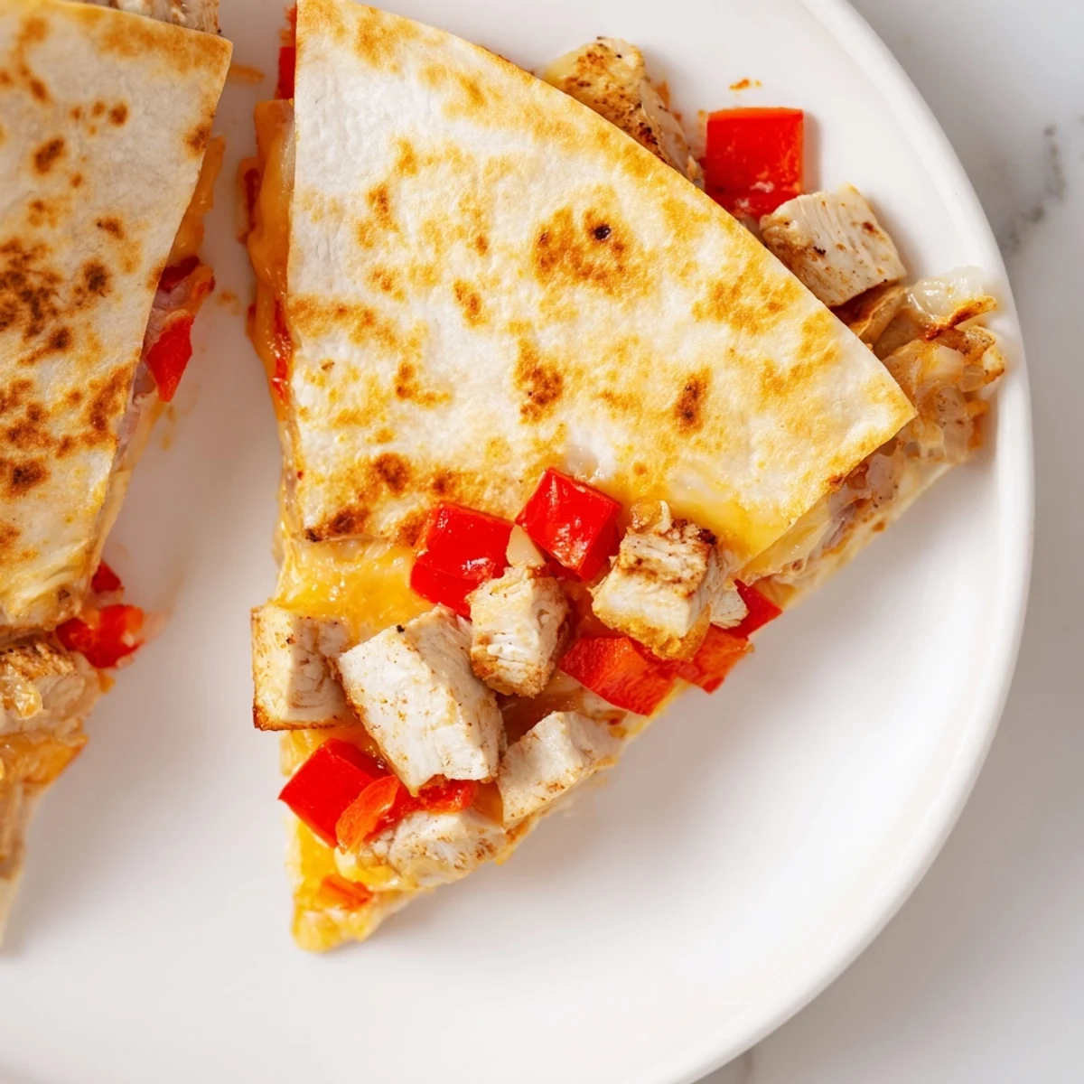 A skillet of Championship Chicken Quesadillas with Guacamole is served with a vibrant bowl of salsa and sour cream.