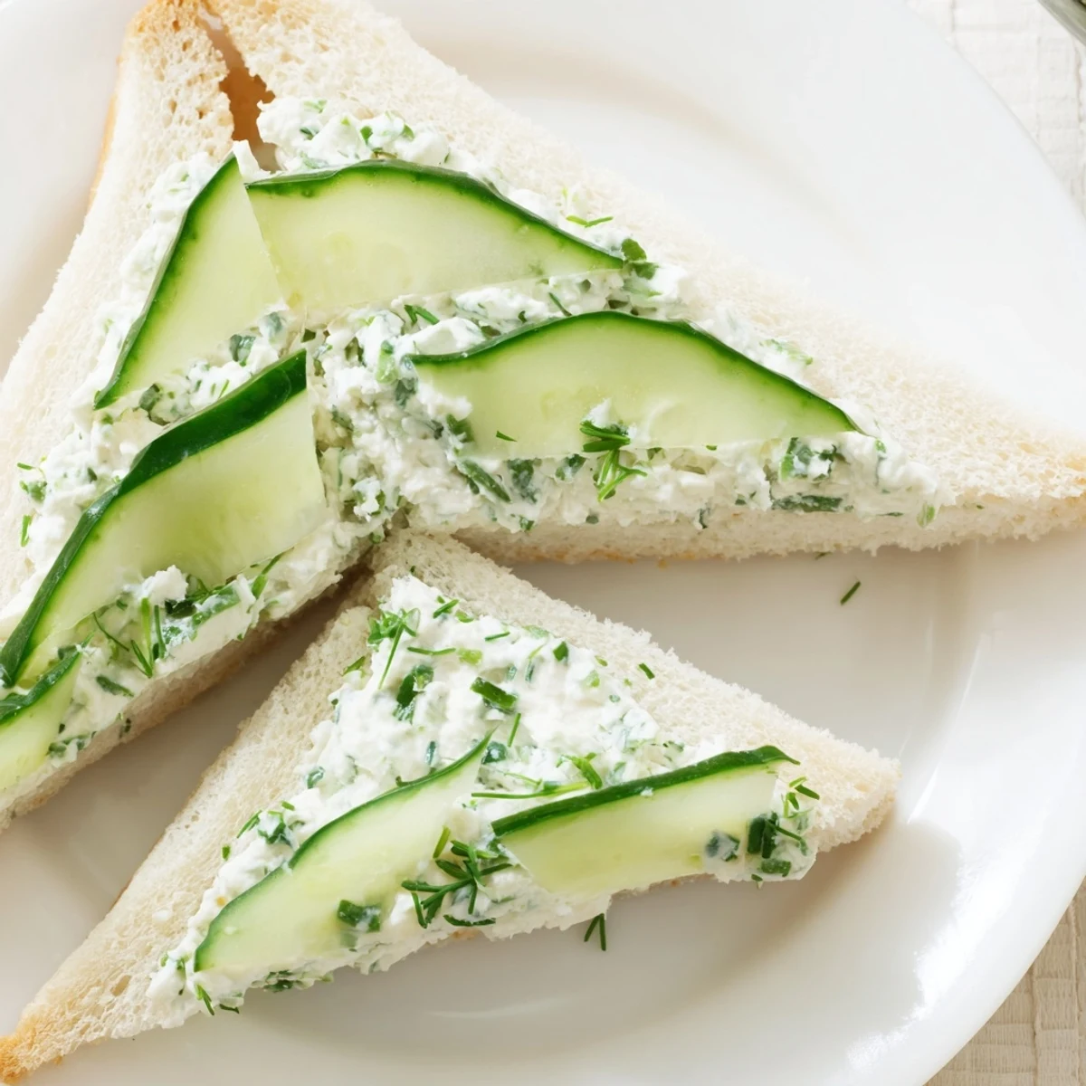 Freshly made Cucumber Sandwiches with Herb Cream Cheese stacked neatly, featuring thinly sliced English cucumbers and crustless soft bread. 
