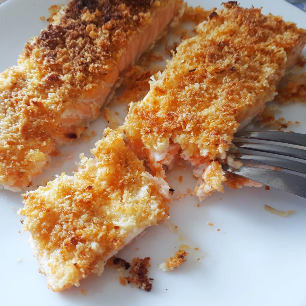 Flaky salmon topped with crunchy Parmesan crust, baked until golden brown and served with parsley garnish.