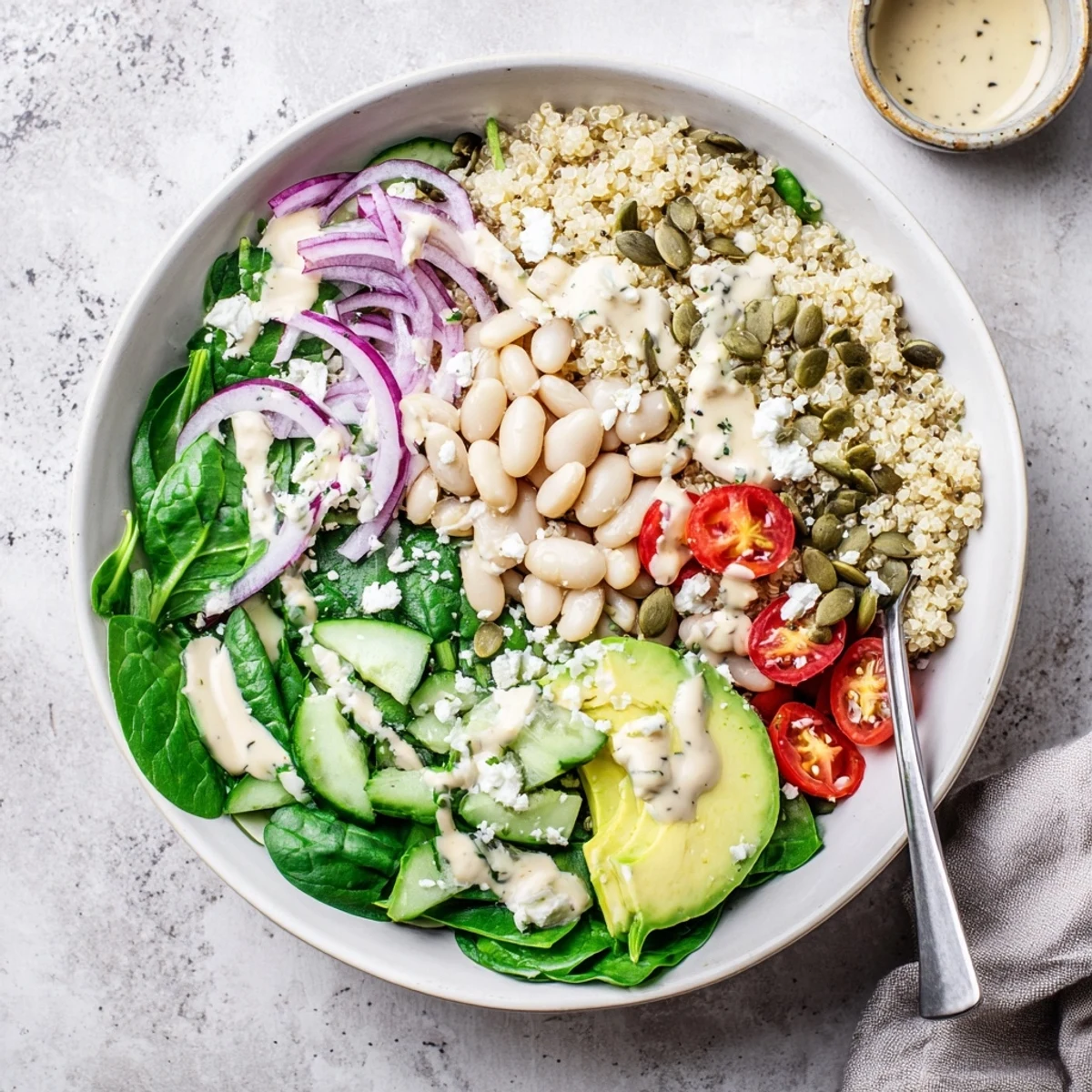 A vibrant Spinach & White Bean Ultimate Protein Power Bowl topped with creamy avocado and pumpkin seeds.