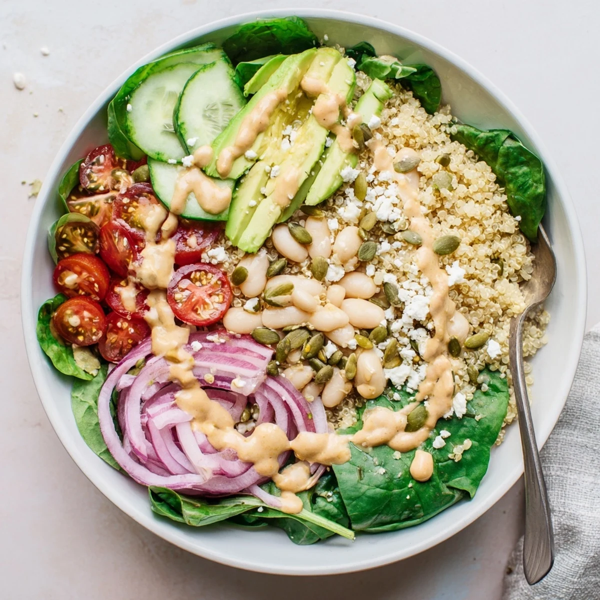 Fresh Spinach & White Bean Ultimate Protein Power Bowl served in a rustic bowl with cucumbers and red onion.