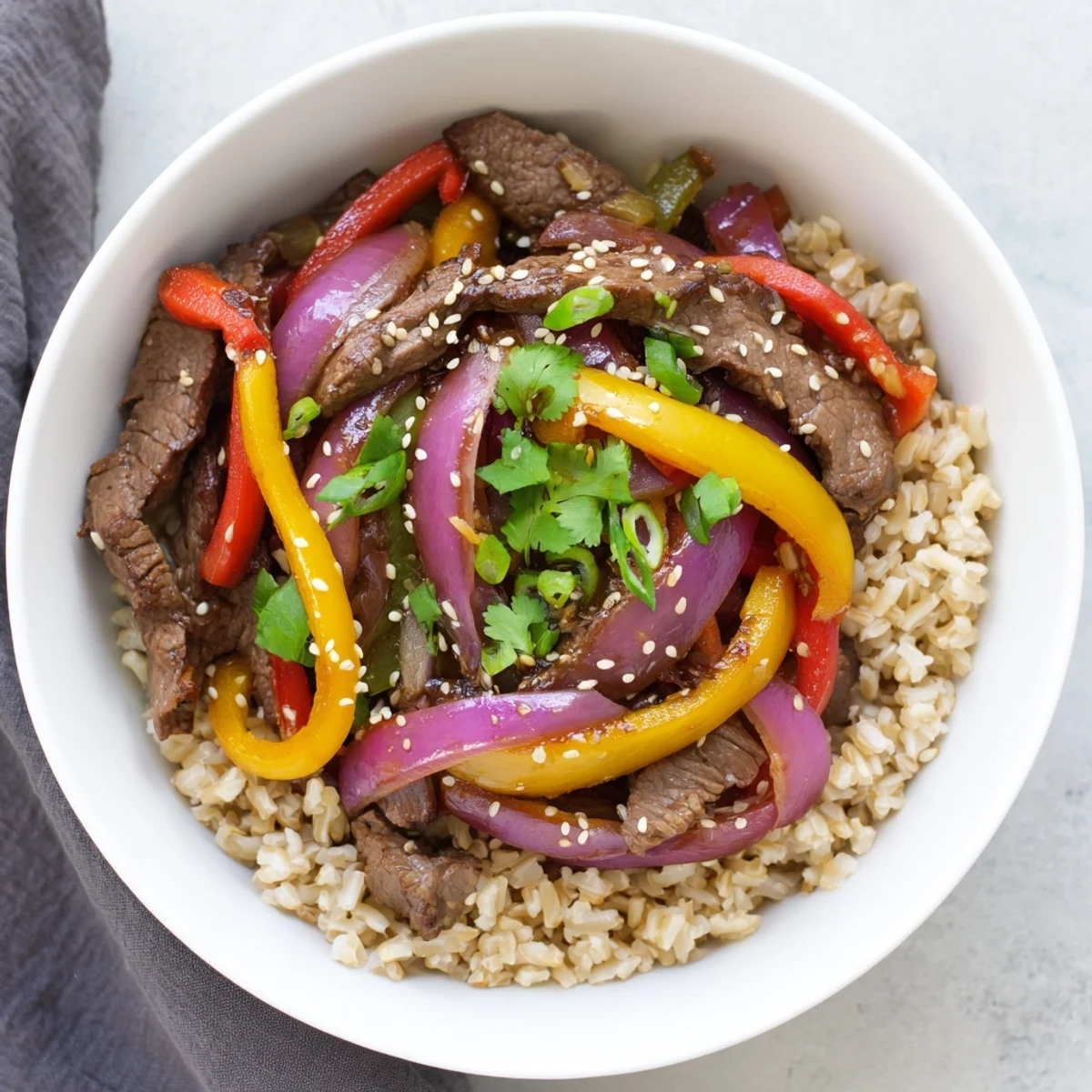 Freshly stir-fried Healthy Beef and Pepper Rice Bowl with colorful vegetables and steaming brown rice.
