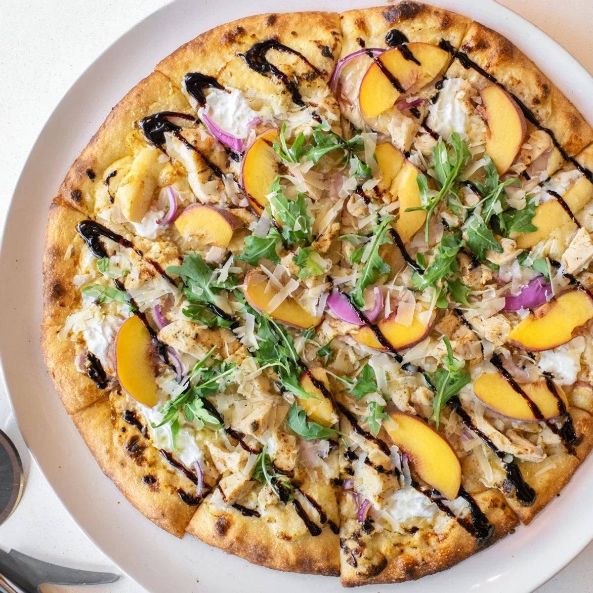 Crisp crust pizza topped with juicy peaches, tender chicken, and creamy ricotta cheese