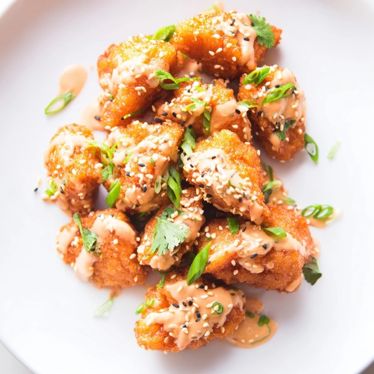 Crispy fried Spicy Bang Bang Chicken tossed in sweet chili Sriracha sauce topped with cilantro