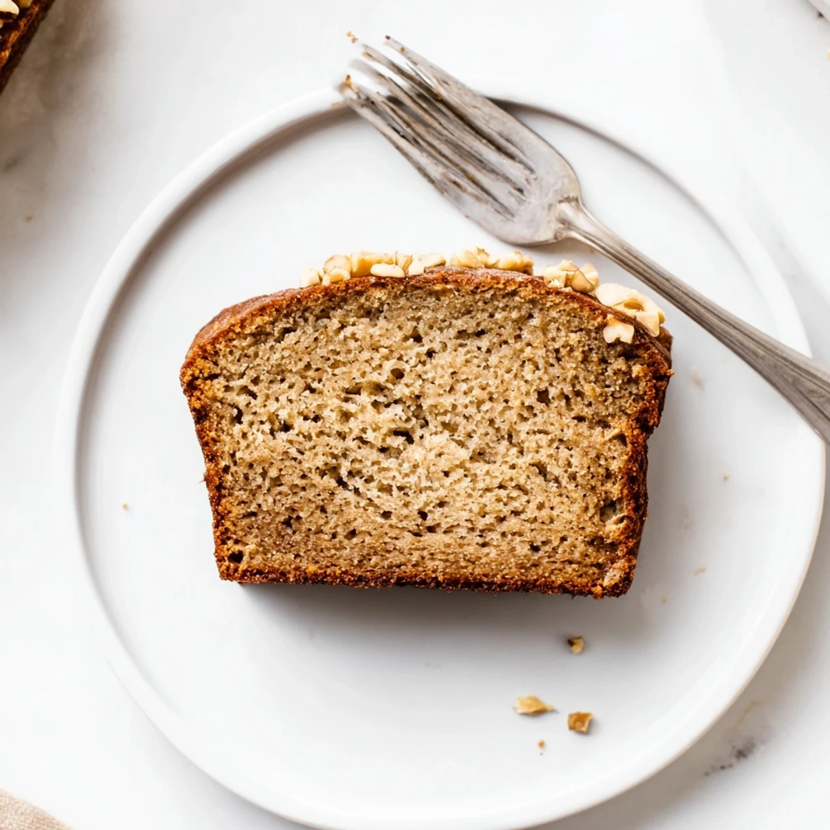 Golden loaf of moist banana bread with sour cream sliced on a wooden board