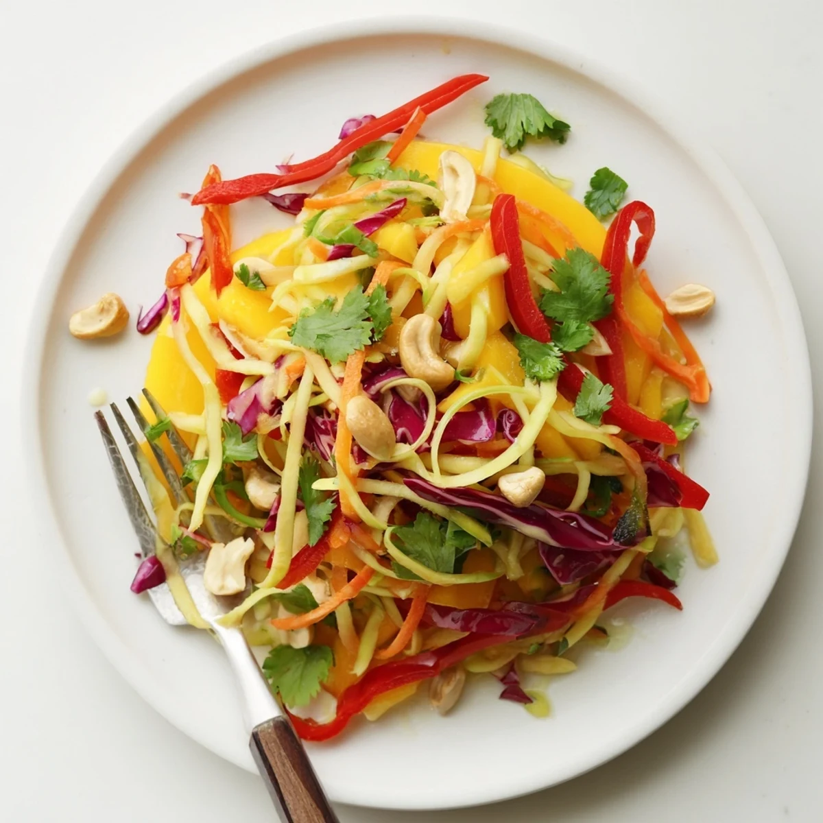Tangy mango slaw featuring julienned mango, crisp cabbage, and peppers in citrus dressing