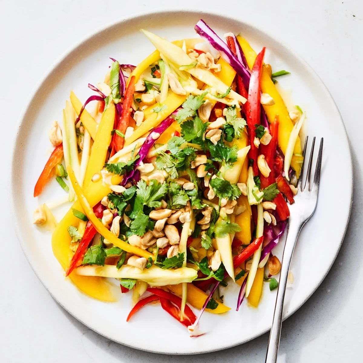 Fresh mango slaw topped with crunchy cashews and vibrant vegetables for a refreshing side