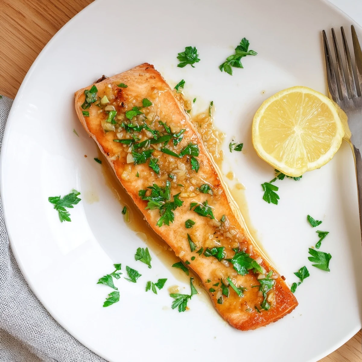 Golden pan-seared salmon fillets coated in sticky honey garlic glaze with fresh parsley garnish