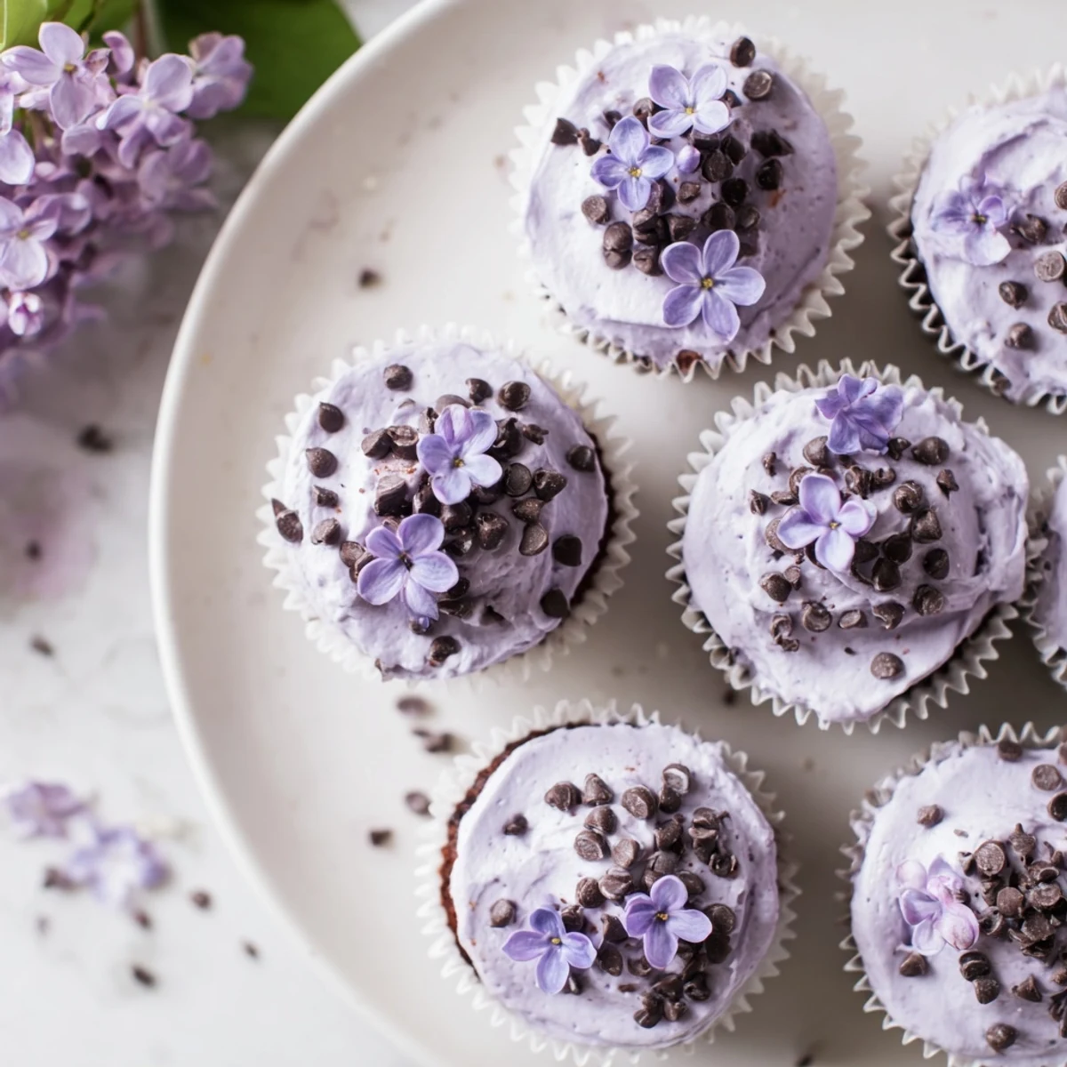 Floral lilac chocolate cupcakes with swiped buttercream and delicate lilac petals for spring dessert