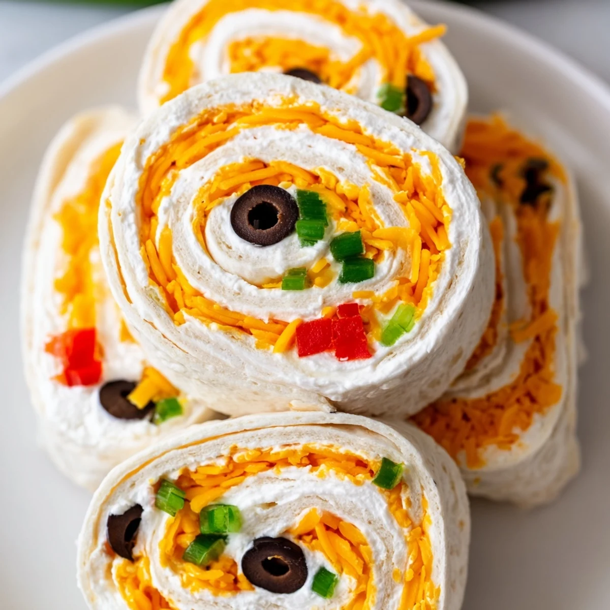 Close-up of bite-sized easy tortilla pinwheels arranged on a white serving platter