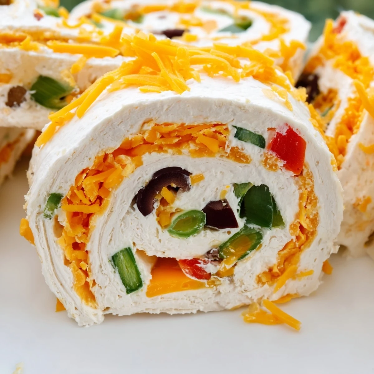 Rolled flour tortillas stuffed with cheddar cream cheese mixture sliced into pinwheel appetizers