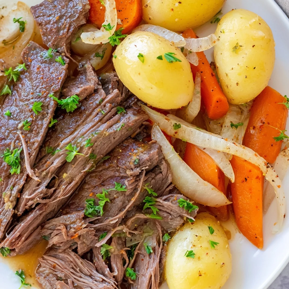 Hearty slow cooker steak and potatoes garnished with fresh parsley in a serving bowl