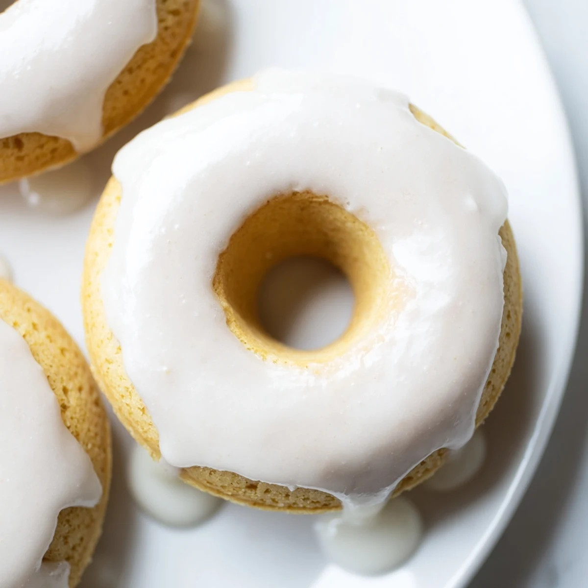 Golden Greek yogurt cake donuts glazed with sweet vanilla icing on a wire rack