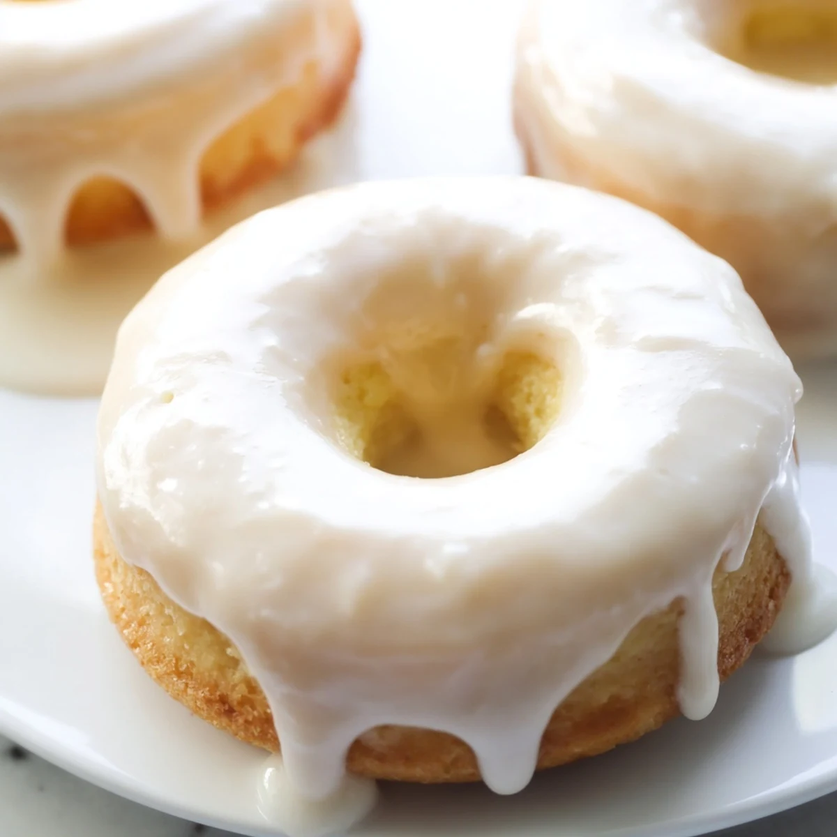Baked Greek yogurt cake donuts with cinnamon dusting arranged on a white serving plate