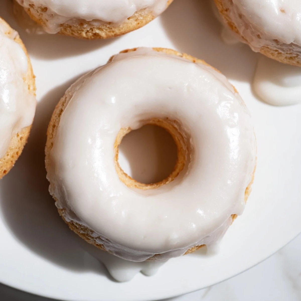 Freshly baked Greek yogurt cake donuts topped with colorful sprinkles and vanilla glaze