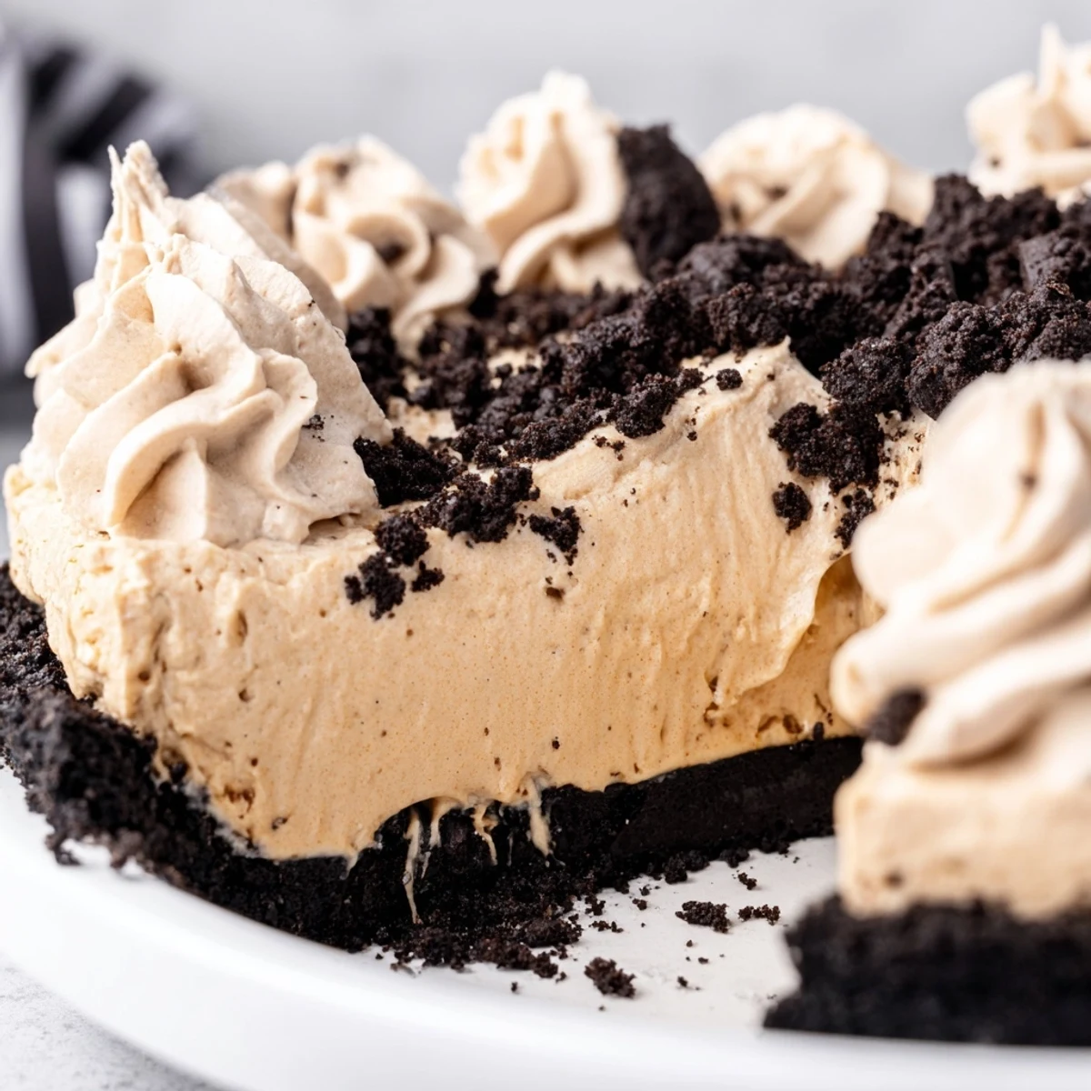 Rich chocolate crust cradles silky smooth peanut butter Oreo pie filling with crushed garnish