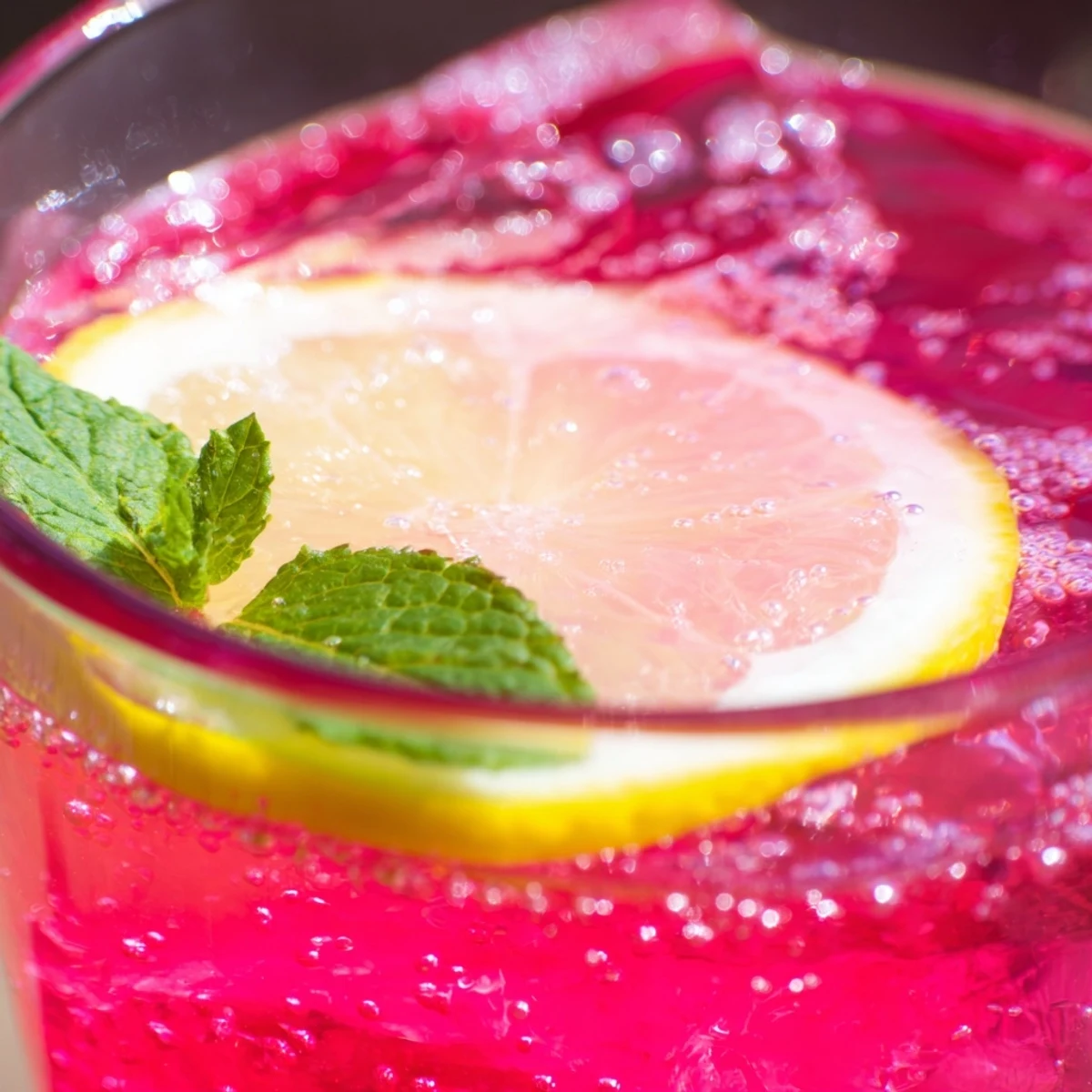Sparkling honey lemon pink soda served over ice with fresh mint garnish