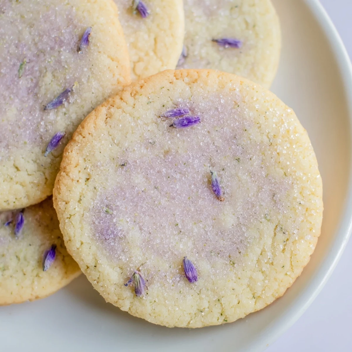 Buttery lilac sugar cookies served on a vintage plate beside a cup of herbal tea