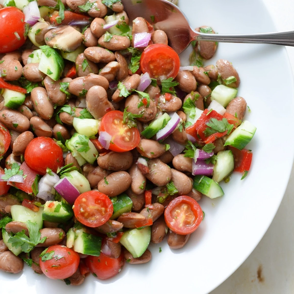 Colorful pinto bean salad in a rustic bowl tossed with tomatoes and cilantro