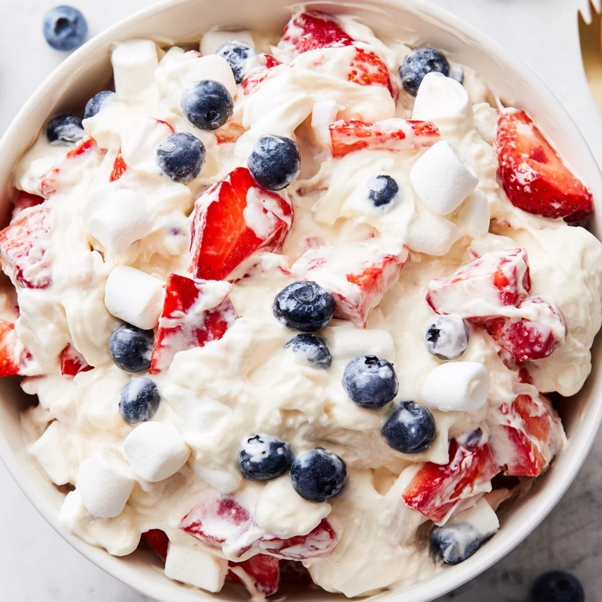 Vibrant Red White Blue Cheesecake Salad scooped into a chilled summer dessert bowl