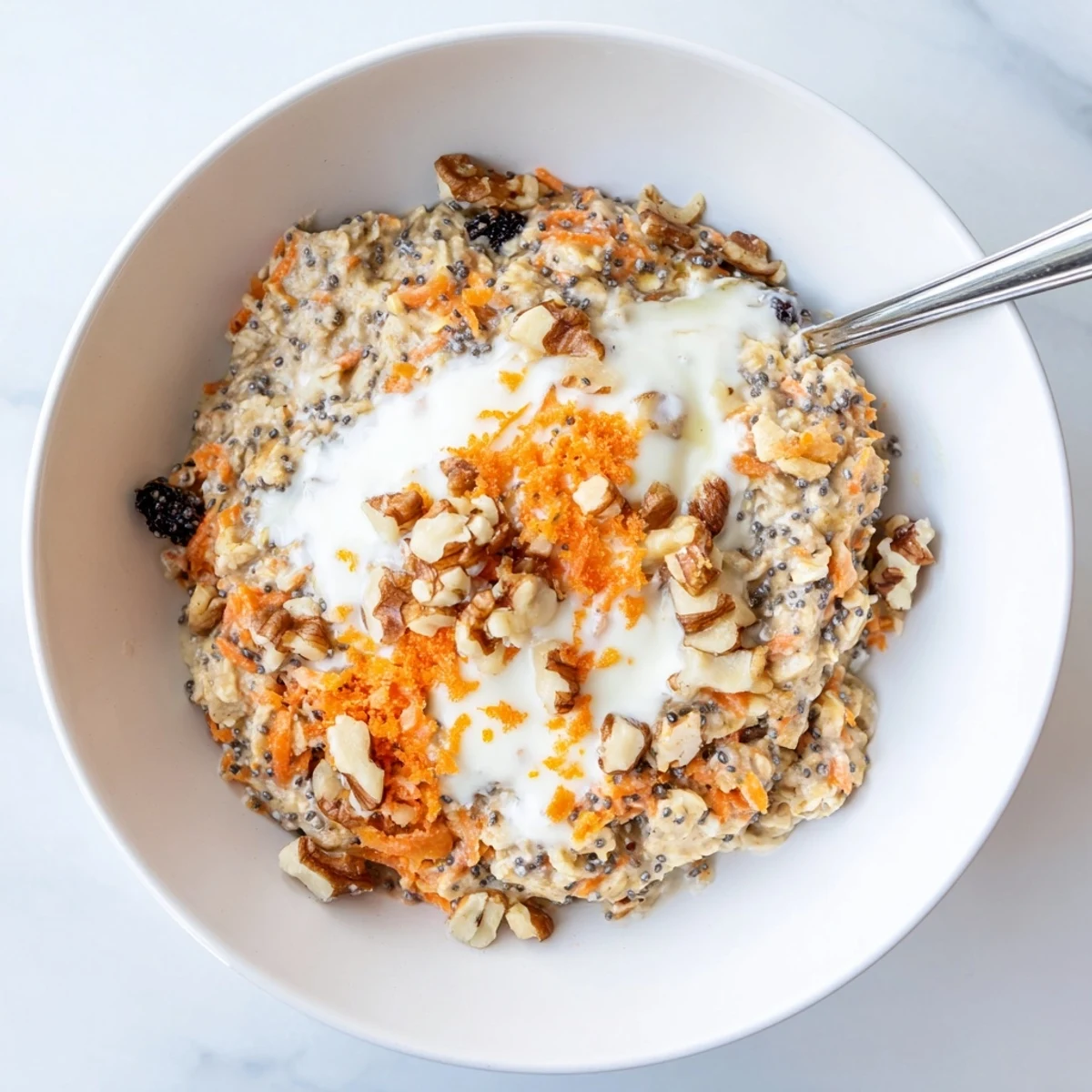 Thick chilled carrot cake overnight oats layered with pecans and a drizzle of maple syrup