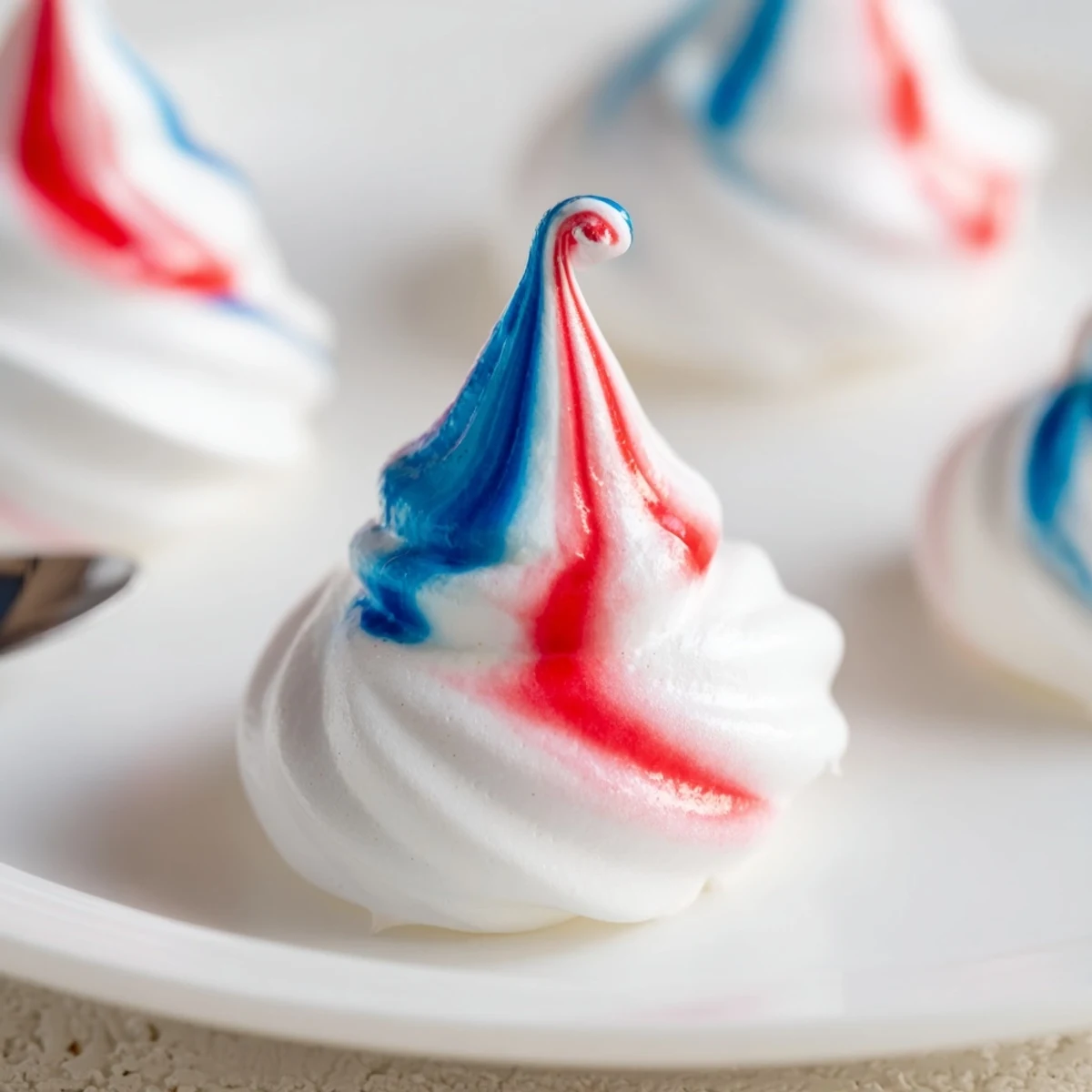 Patriotic Meringue Kisses: crisp red, white, blue shells on parchment