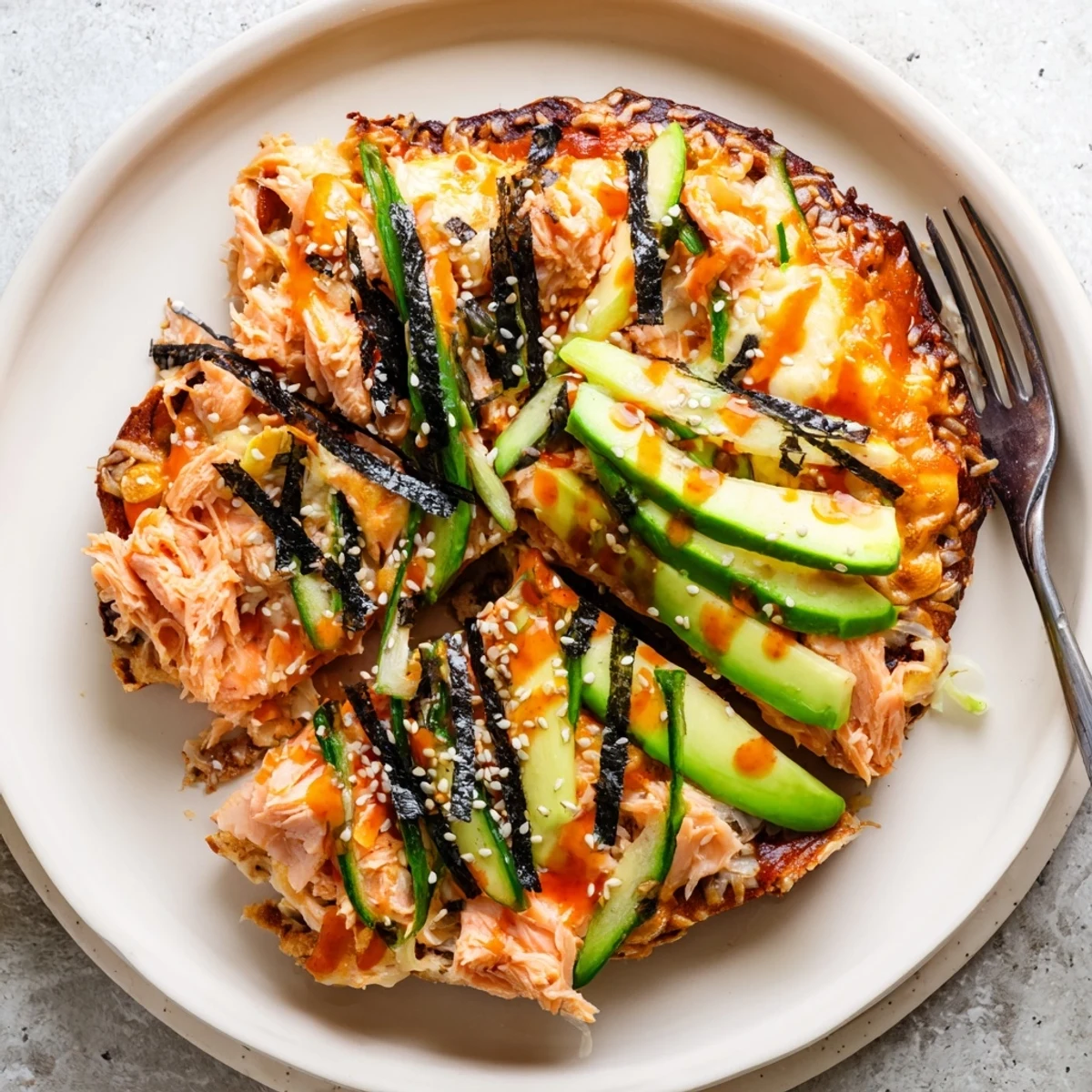 Fusion sushi bake flatbread finished with cool cucumber ribbons and fiery sriracha sauce
