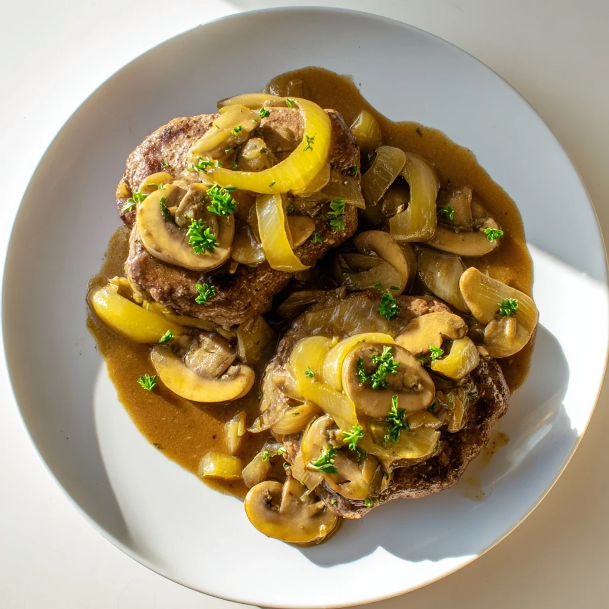 Golden brown country style smothered cube steak simmering in rich onion mushroom gravy