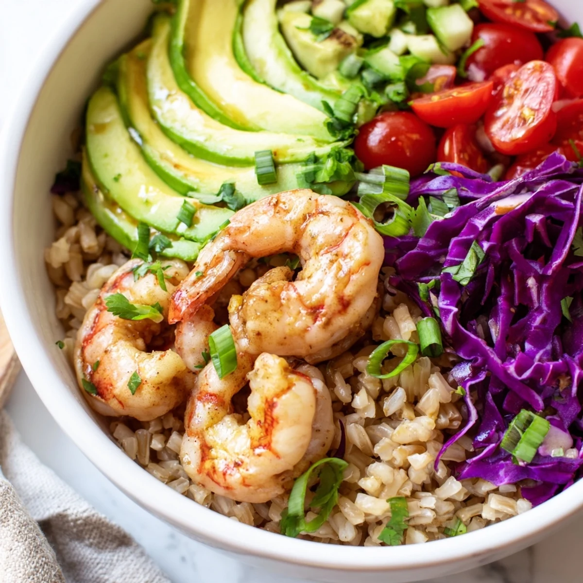Sizzling smoked paprika shrimp grain bowl topped with colorful fresh vegetables and creamy avocado