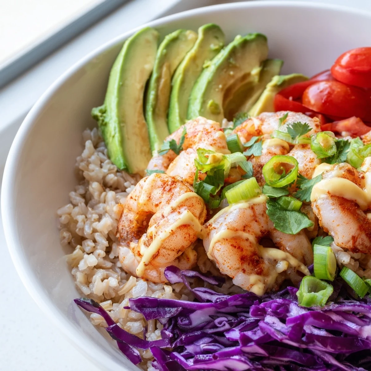 Vibrant shrimp grain bowl drizzled with tangy honey lime dressing over fluffy brown rice