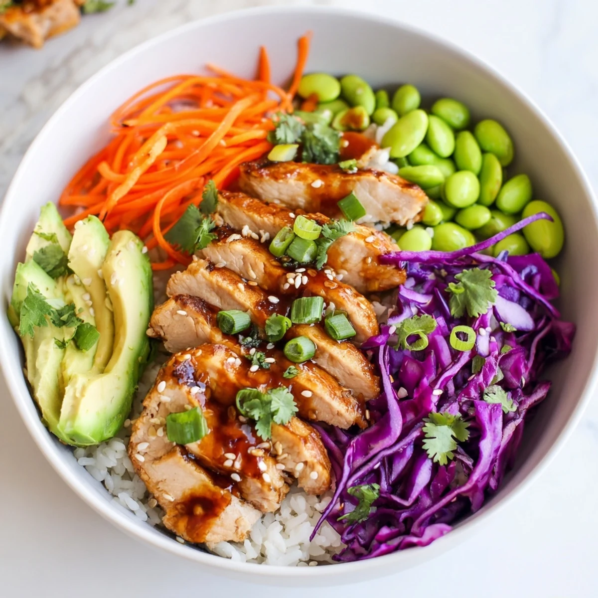 Colorful Asian-inspired chicken power bowl with sesame chicken and fresh vegetables on brown rice.