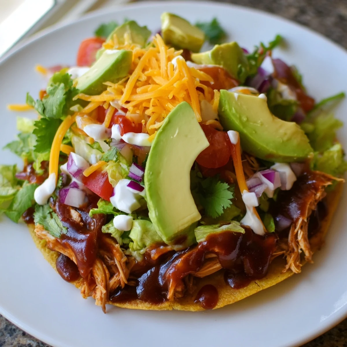 Crispy sweet smoky BBQ chicken tostadas loaded with fresh lettuce, tomato, and melted cheese