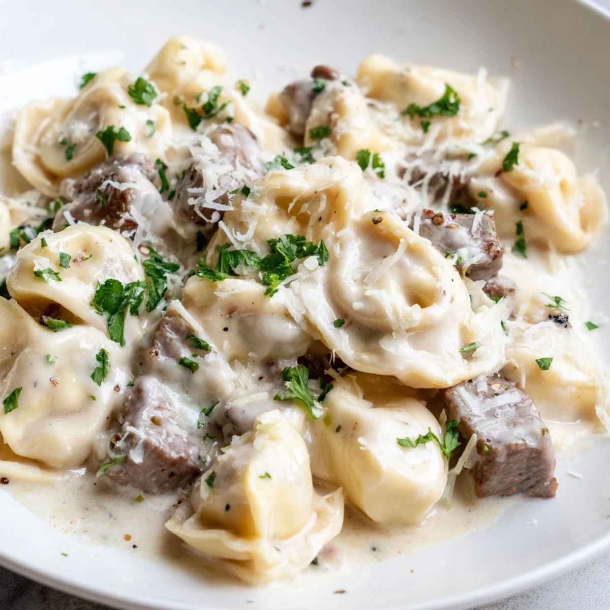 Cheesy tortellini and seared steak bites swimming in a rich garlic cream sauce