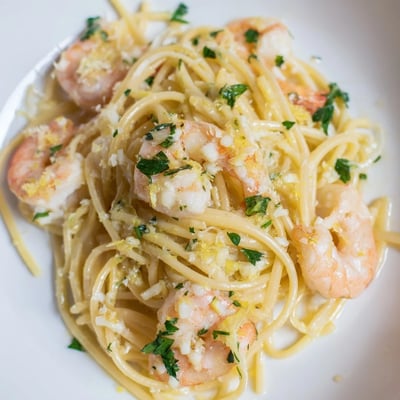 Savory Lemon Shrimp Pasta twirled on a fork, highlighting juicy shrimp and a buttery garlic lemon sauce.