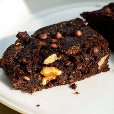 Freshly baked Chocolate Brownie Bites with Nuts rest on a wire cooling rack, with melted chocolate chips visible in the dark crumb.