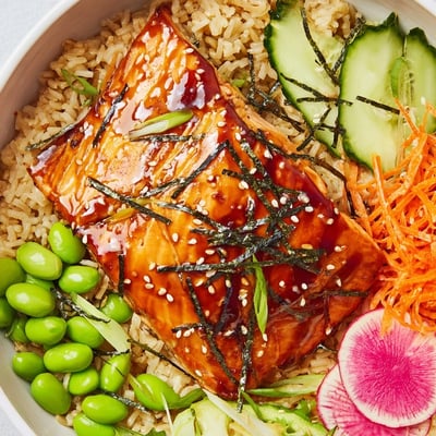 Steaming miso salmon grain bowl served over brown rice with colorful crisp toppings