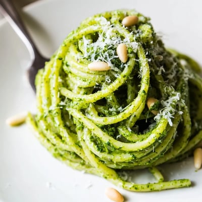 Wild garlic pesto pasta garnished with freshly grated Parmesan and cracked black pepper